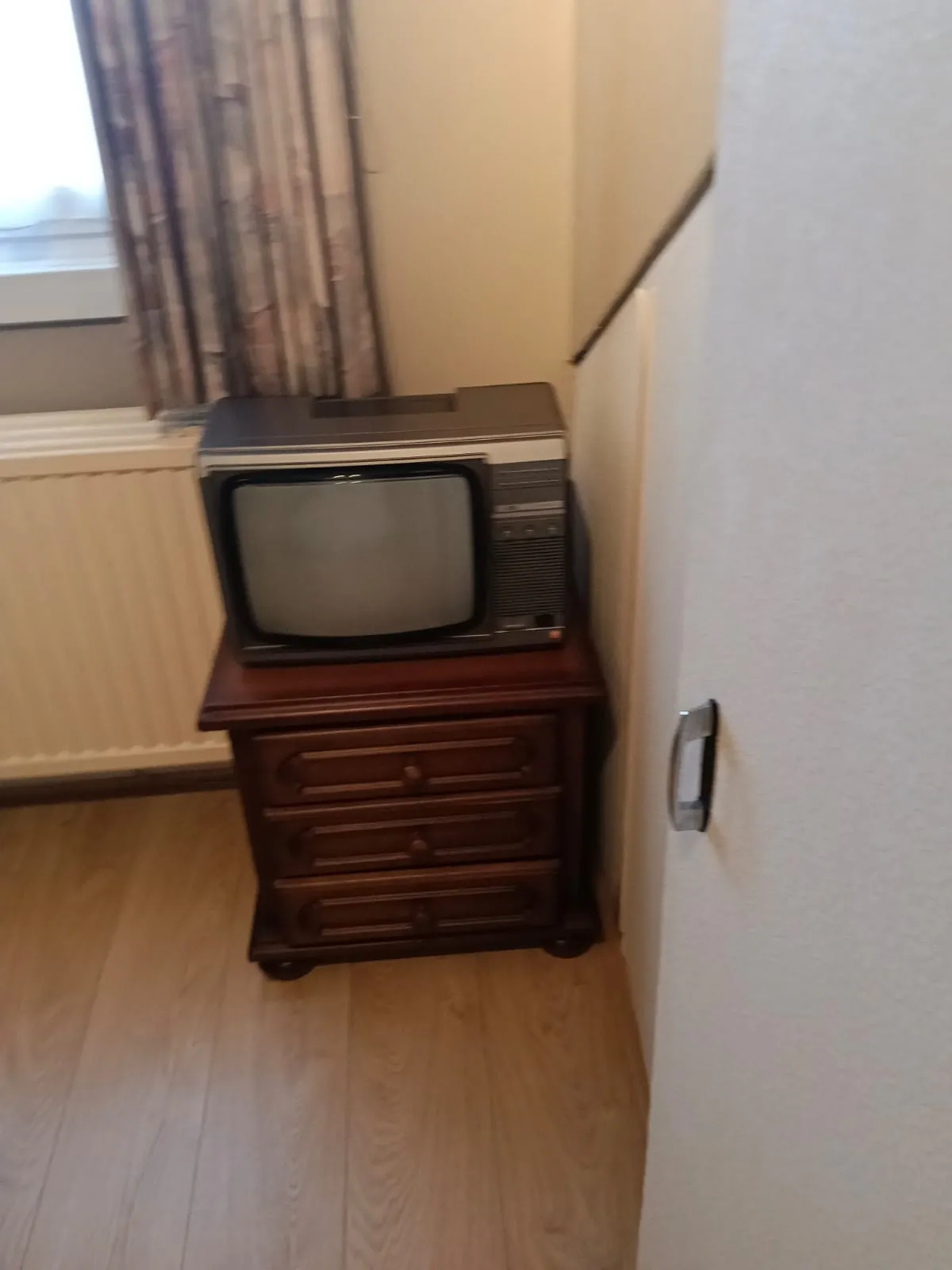 Houten nachtkastje met een oude beeldbuistelevisie